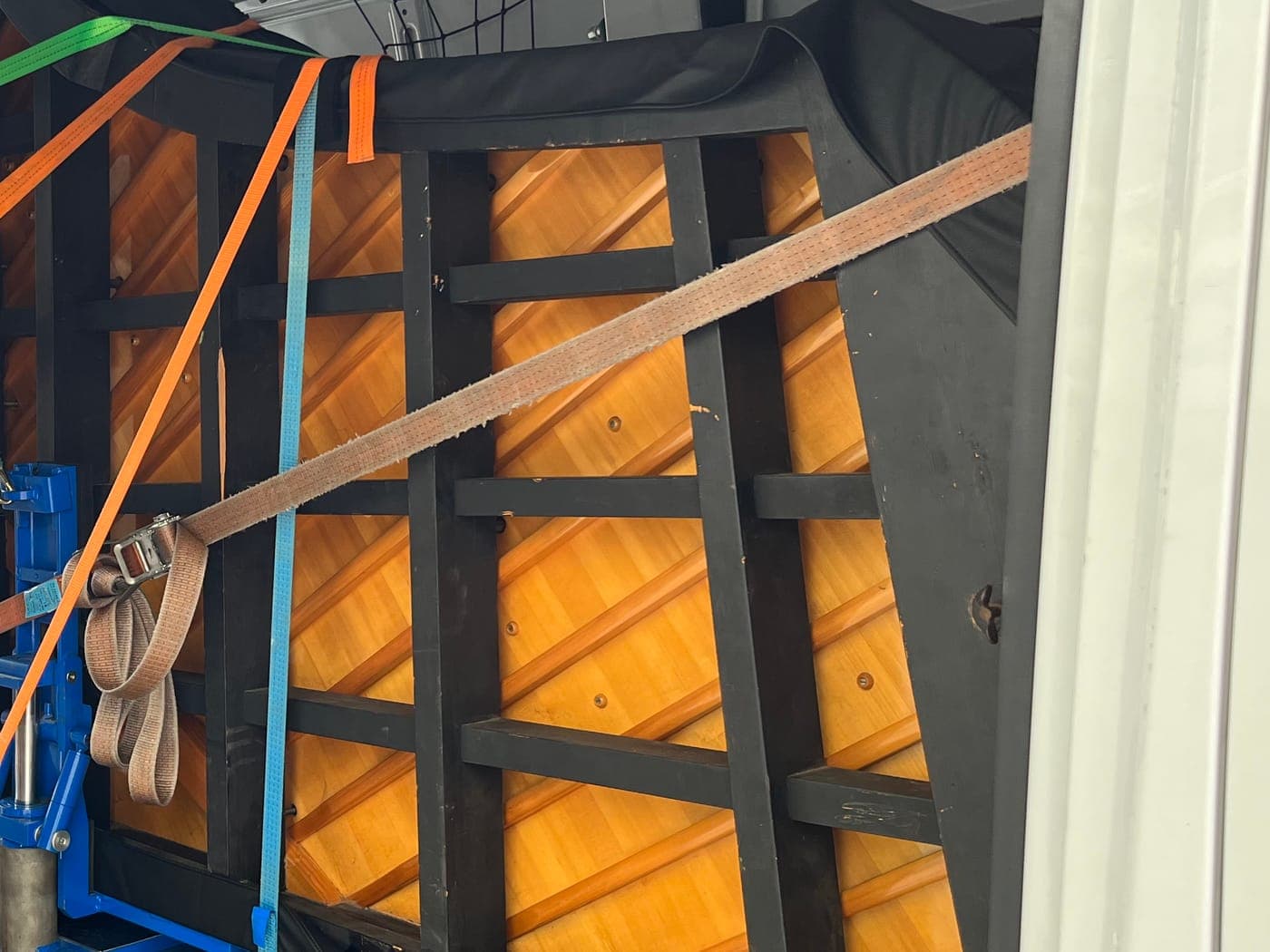 Klavier mit farbigen Spanngurten im Innenraum eines Transporters gesichert