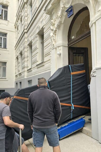 Klavier wird in einen Hauseingang manövriert