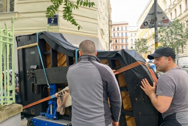 Piano Shift Team transportiert gesichertes Klavier in einer Wiener Straße